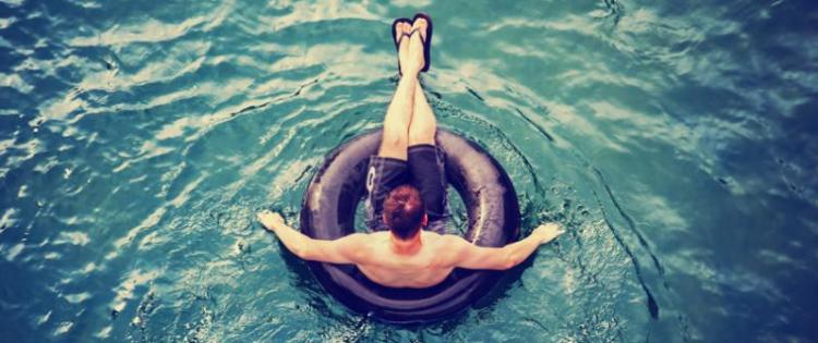 Photo of a man floating on an inner tube.